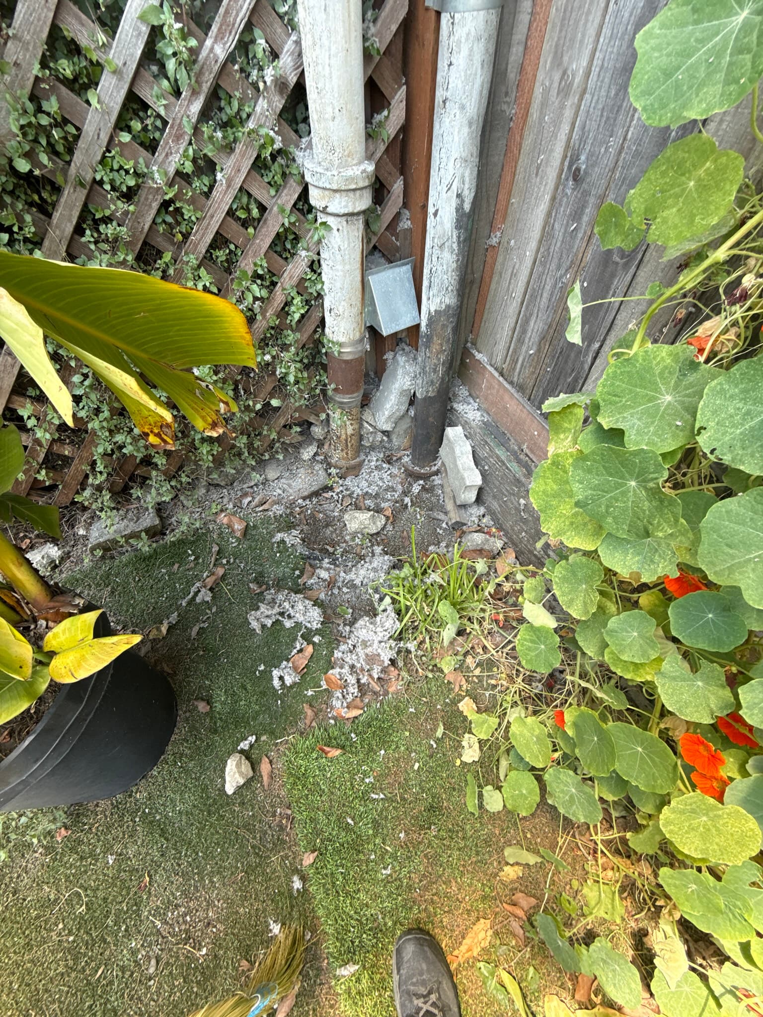 Technician using rotary brush cleaning equipment inside a dryer exhaust duct, with lint debris visible being removed from the duct interior