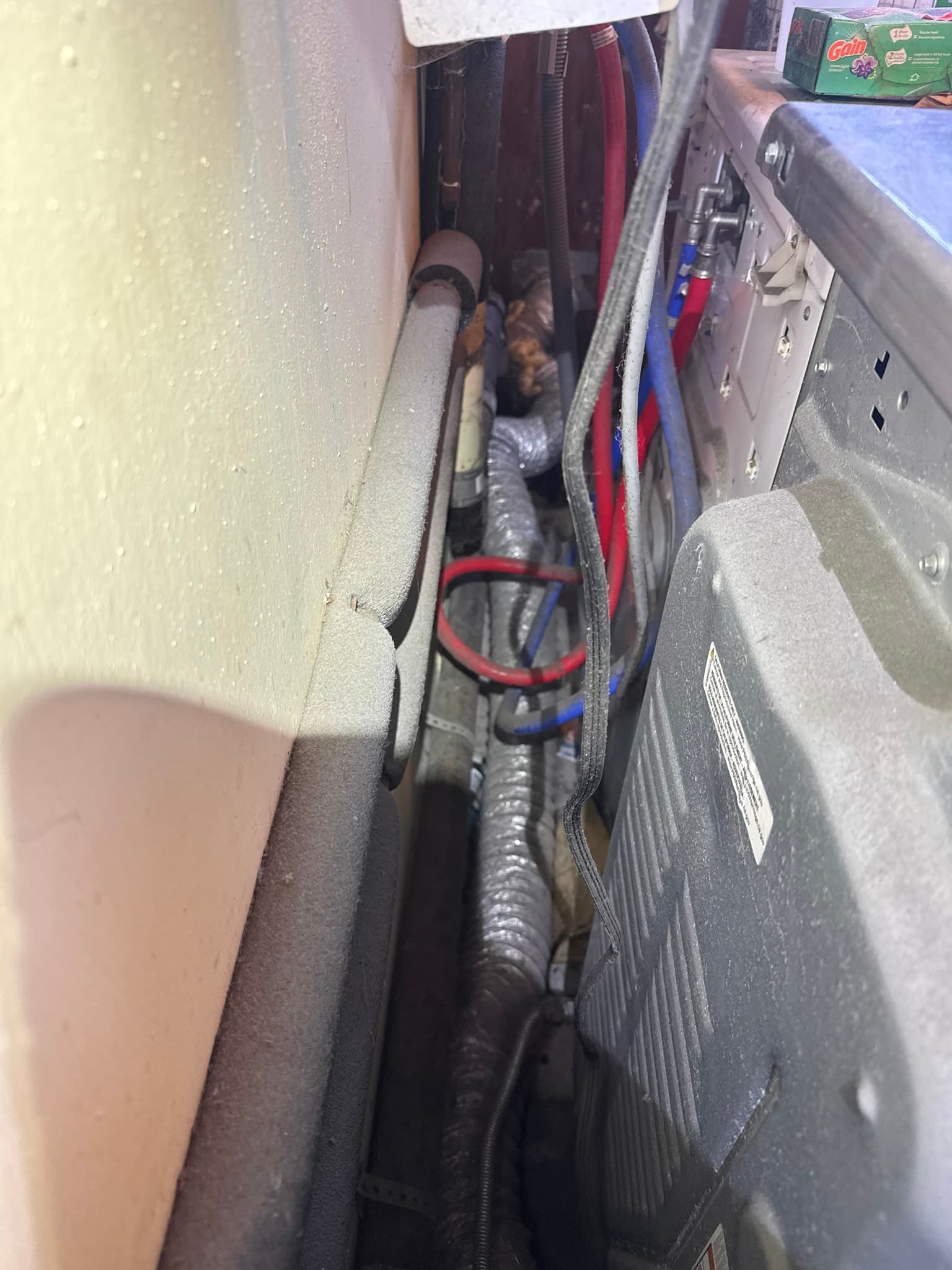 Accordion-style silver foil flexible duct connecting a dryer to the rigid exhaust system, showing the corrugated surface that can trap lint over time