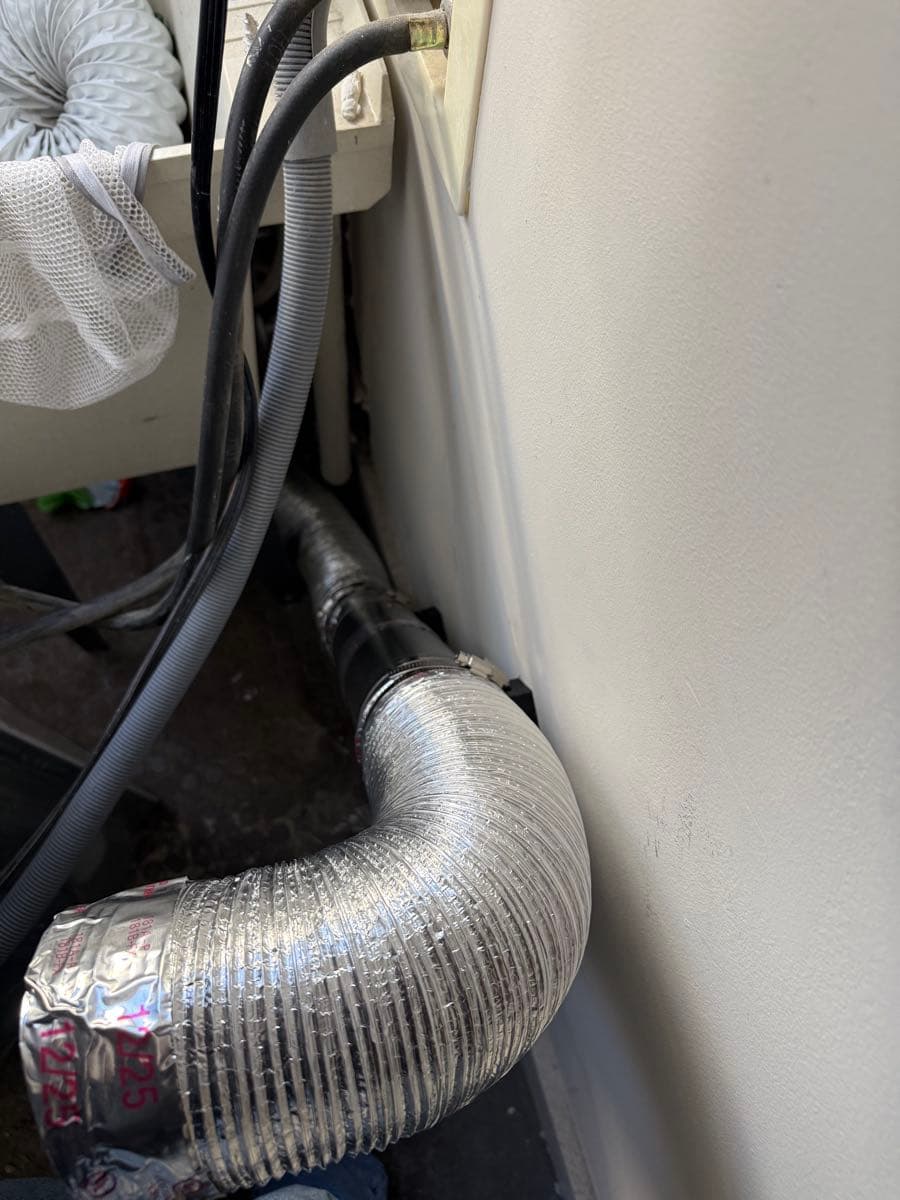 Professional dryer vent installation showing code-compliant metal ductwork