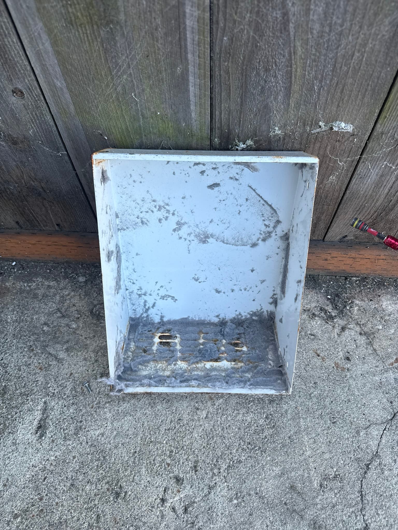 Exterior view of a dryer exhaust termination cap mounted on a residential garage wall in San Francisco