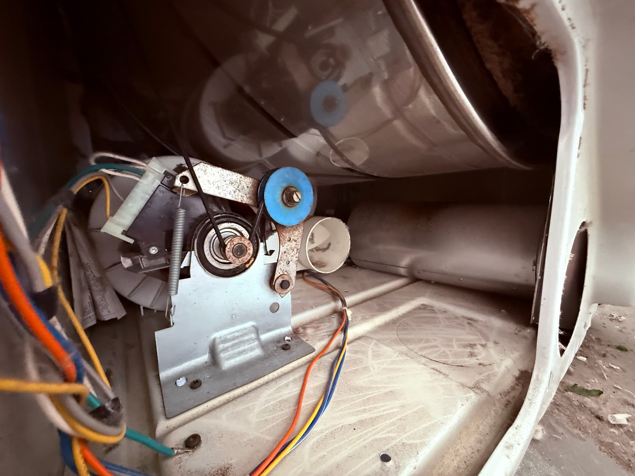 Close-up of a dryer exhaust duct joint secured with metal foil tape on an exposed garage duct run