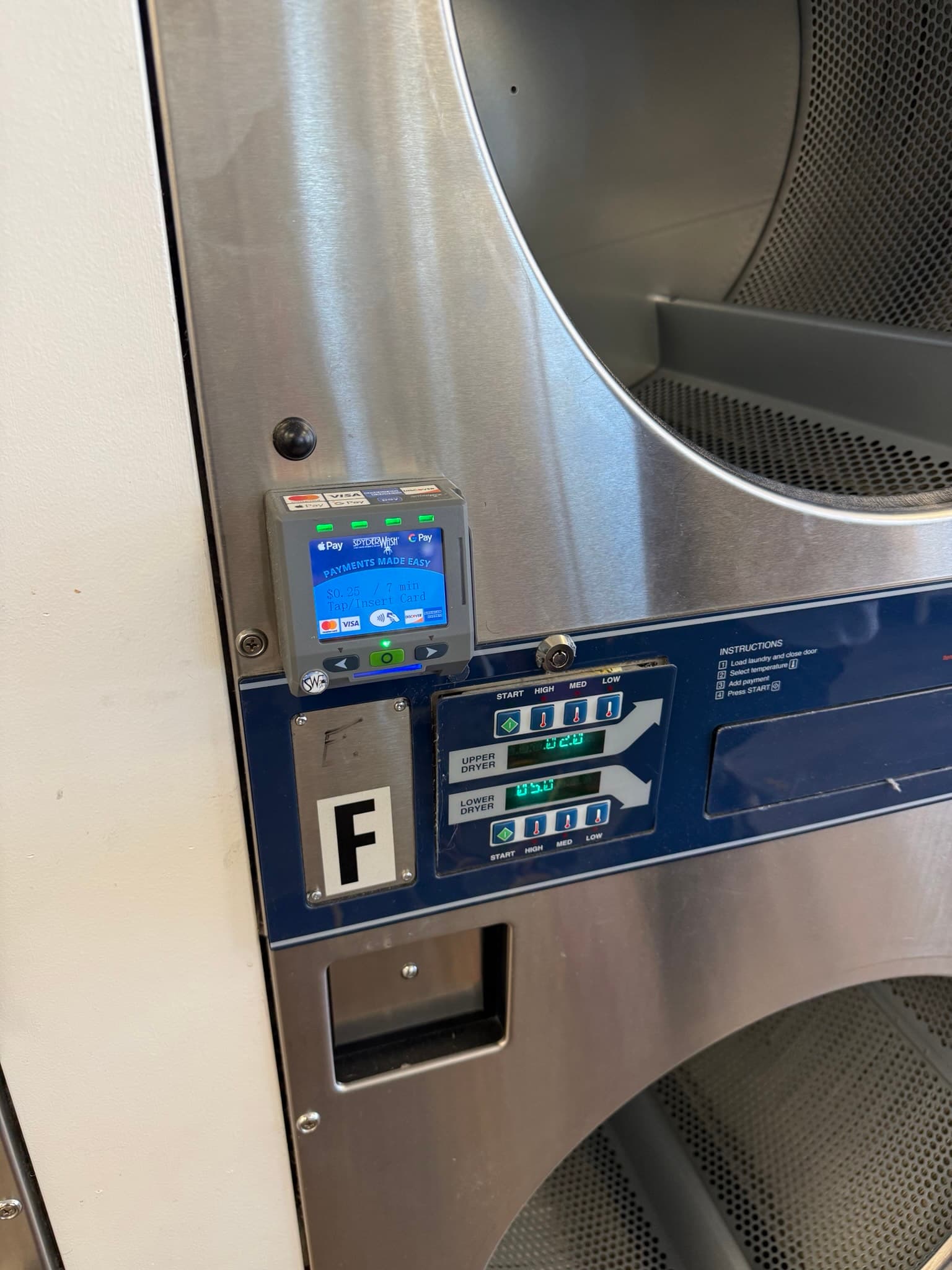 Front view of a stacked commercial Dexter dryer unit showing the control panel and card or coin payment interface in a commercial laundry setting