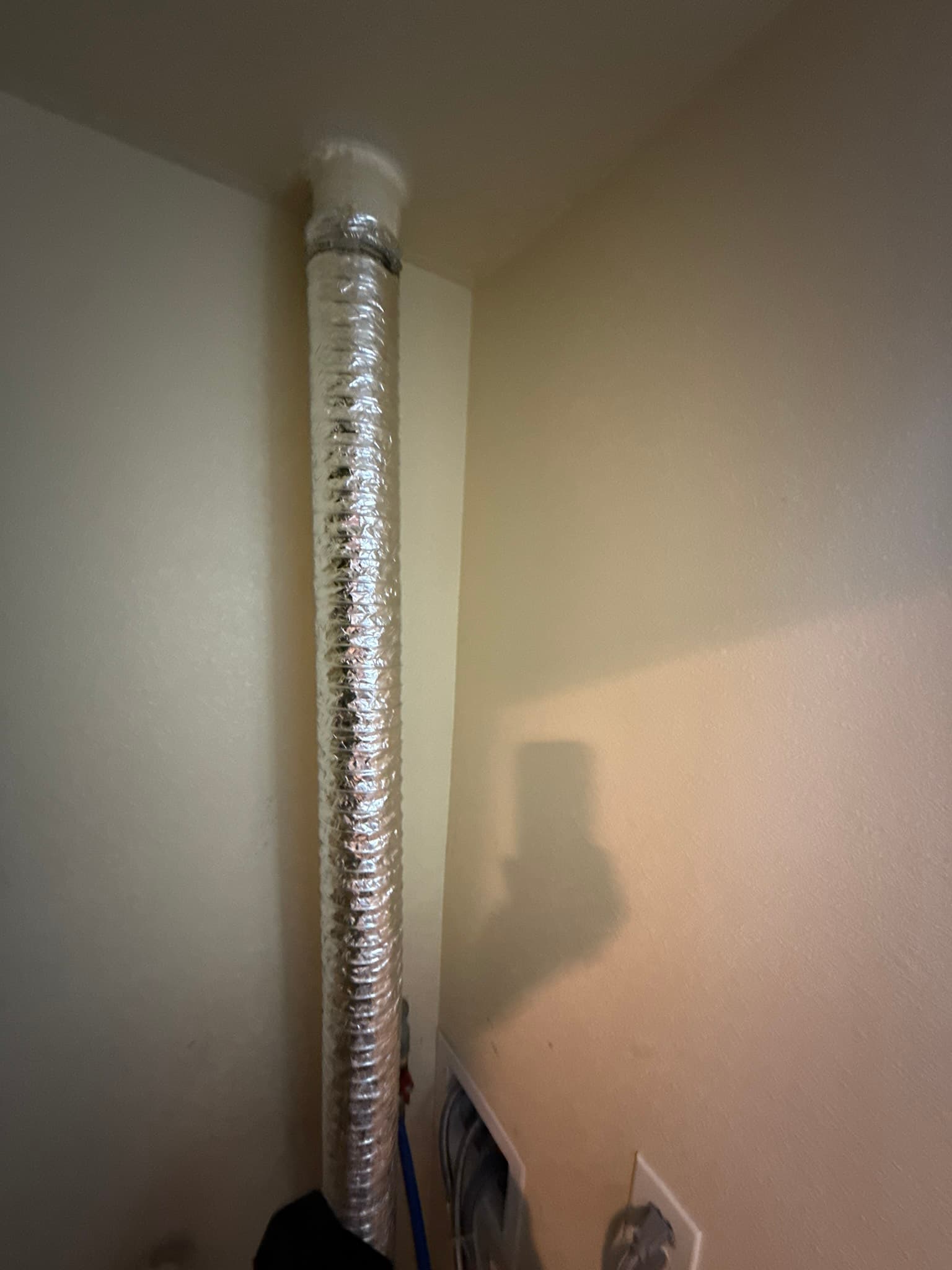 Technician inspecting a residential dryer exhaust duct connection at a South San Francisco home