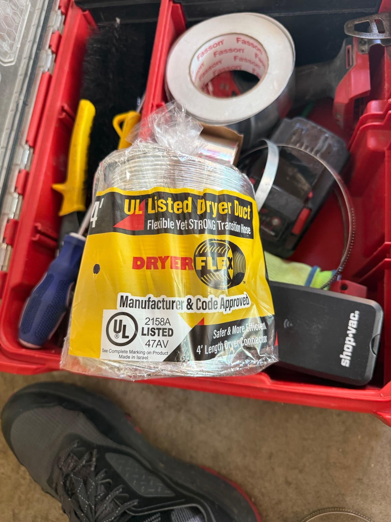 New 4-foot DryerFlex transition duct still in its original packaging inside a red toolbox, showing UL 2158A listing and product markings. Also visible are DryerClamps and other installation materials.