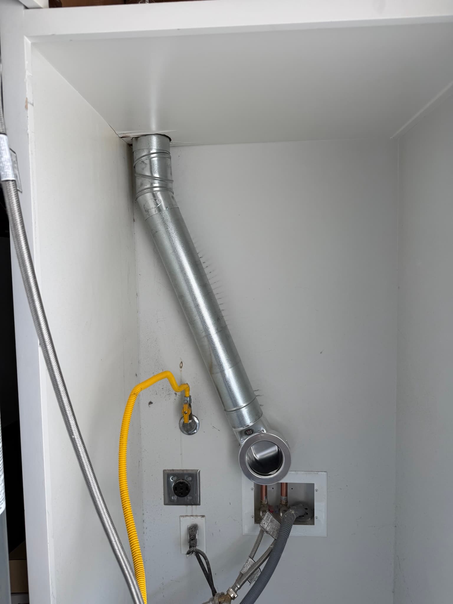General view of dryer vent system components during inspection in a Redwood City residential laundry area