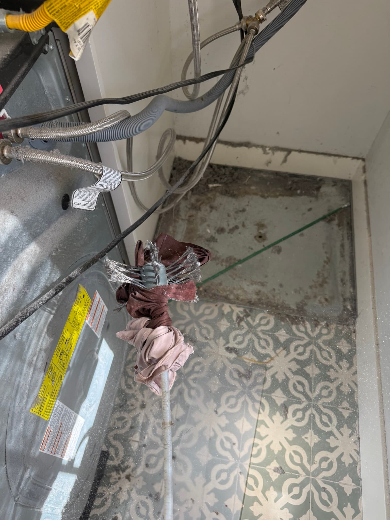 Socks and underwear removed from the burner tube area inside the Electrolux dryer cabinet, where clothing items had passed through the oversized lint trap opening