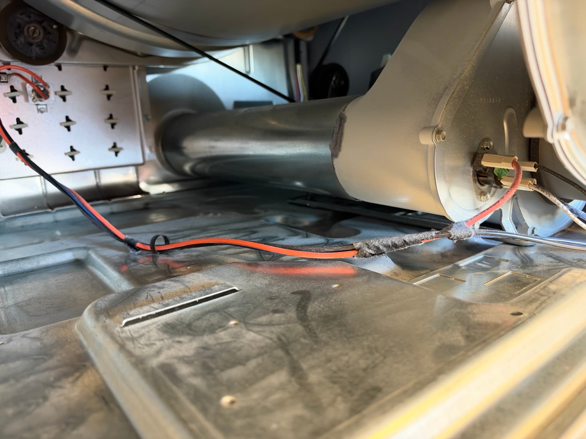 High-powered shop vacuum positioned at the dryer vent opening to extract loosened lint and debris