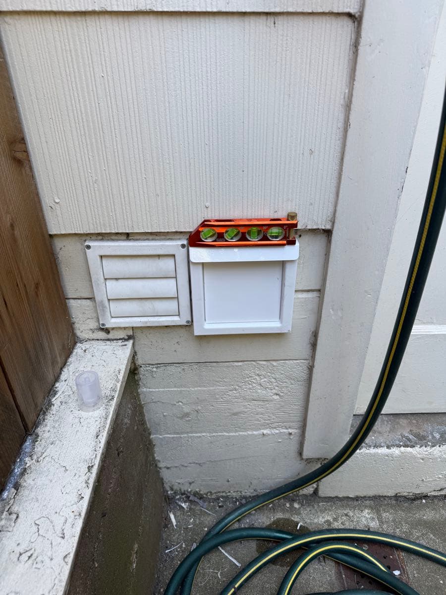 New exterior wall termination with level verification showing properly sealed and aligned installation