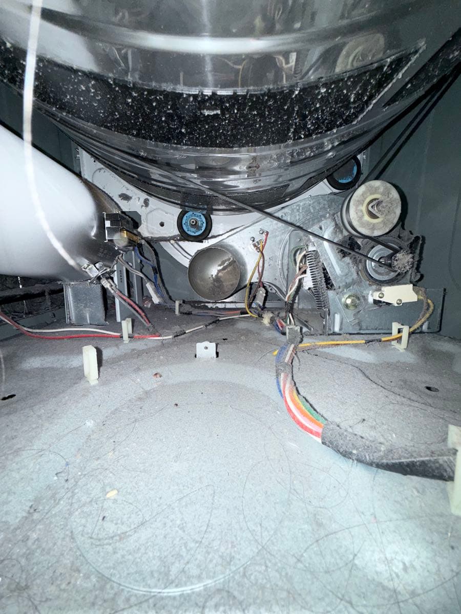 Before cleaning: dryer interior with significant lint accumulation requiring removal