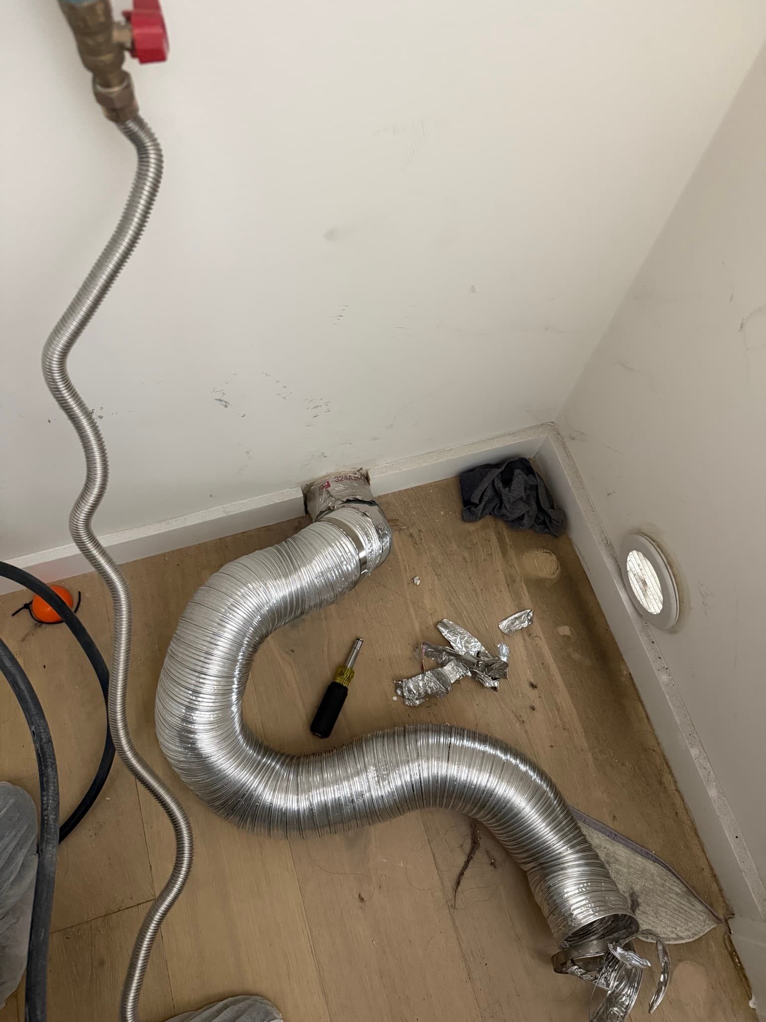 Dryer vent cleaning equipment positioned for thorough duct system maintenance