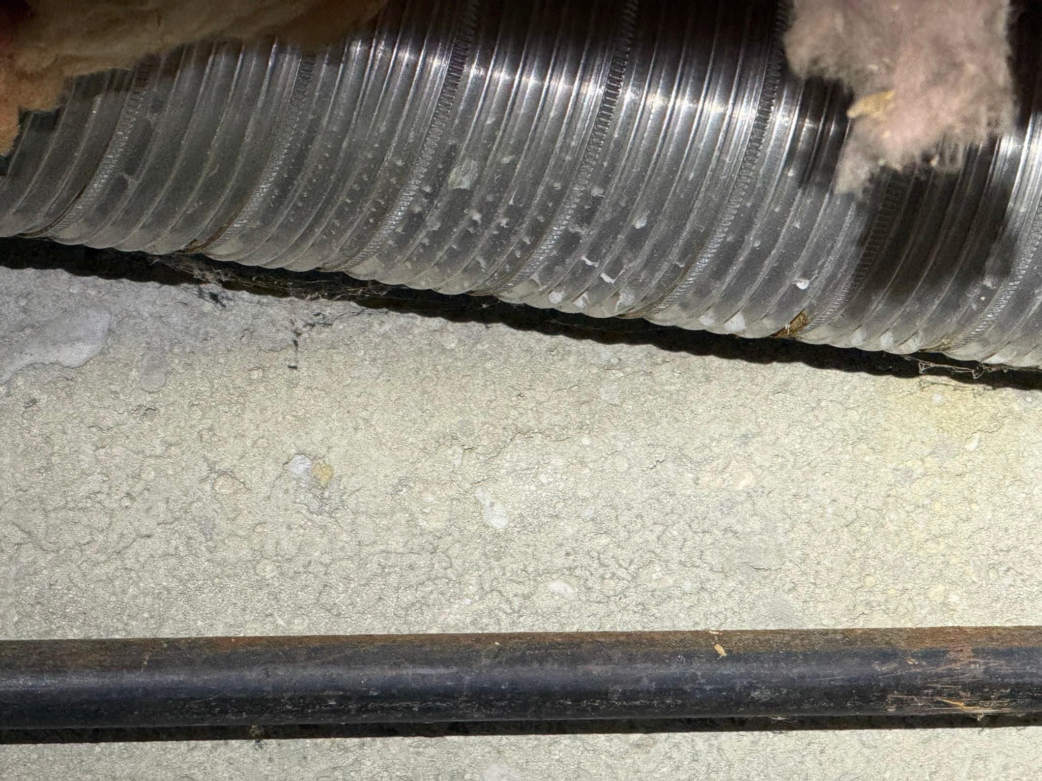 Technician accessing the dryer exhaust duct run for cleaning and inspection