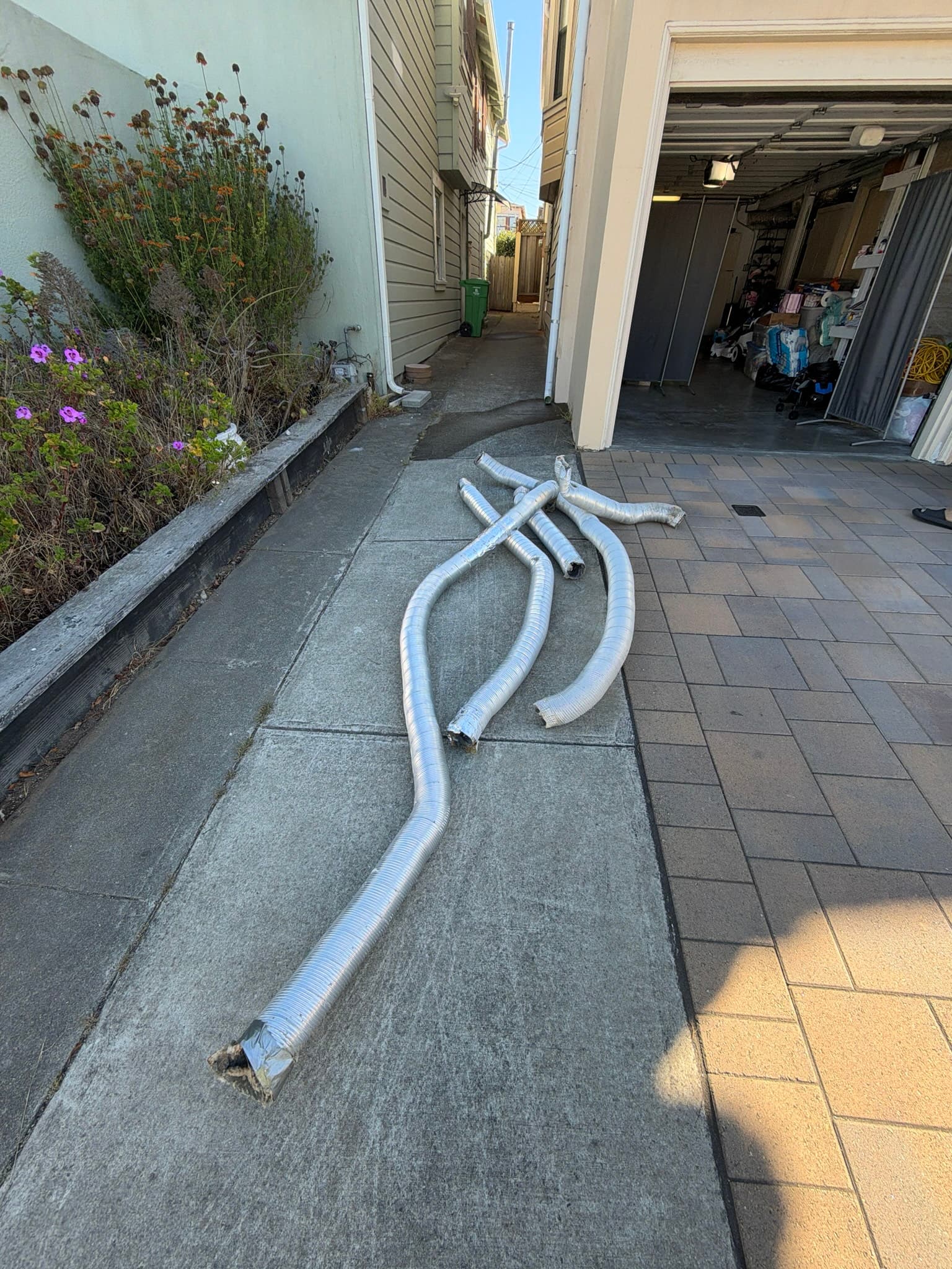 Removed lengths of corroded, crushed semi rigid transition duct laid out on a walkway after being replaced during the exhaust system repair