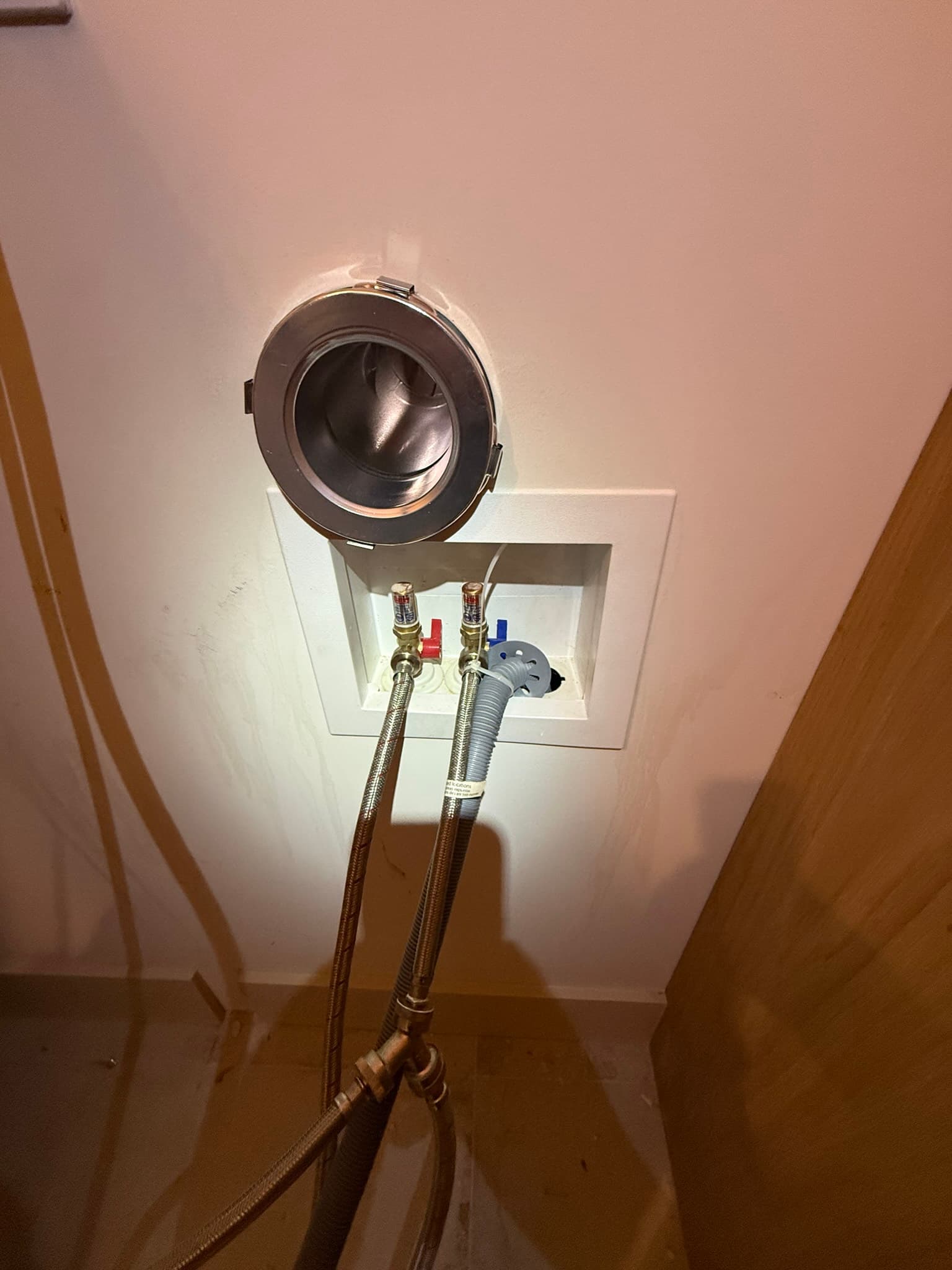MagVent wall-mount receiver installed at the wall, showing the exterior cap and interior connection point for the magnetic dryer vent coupling