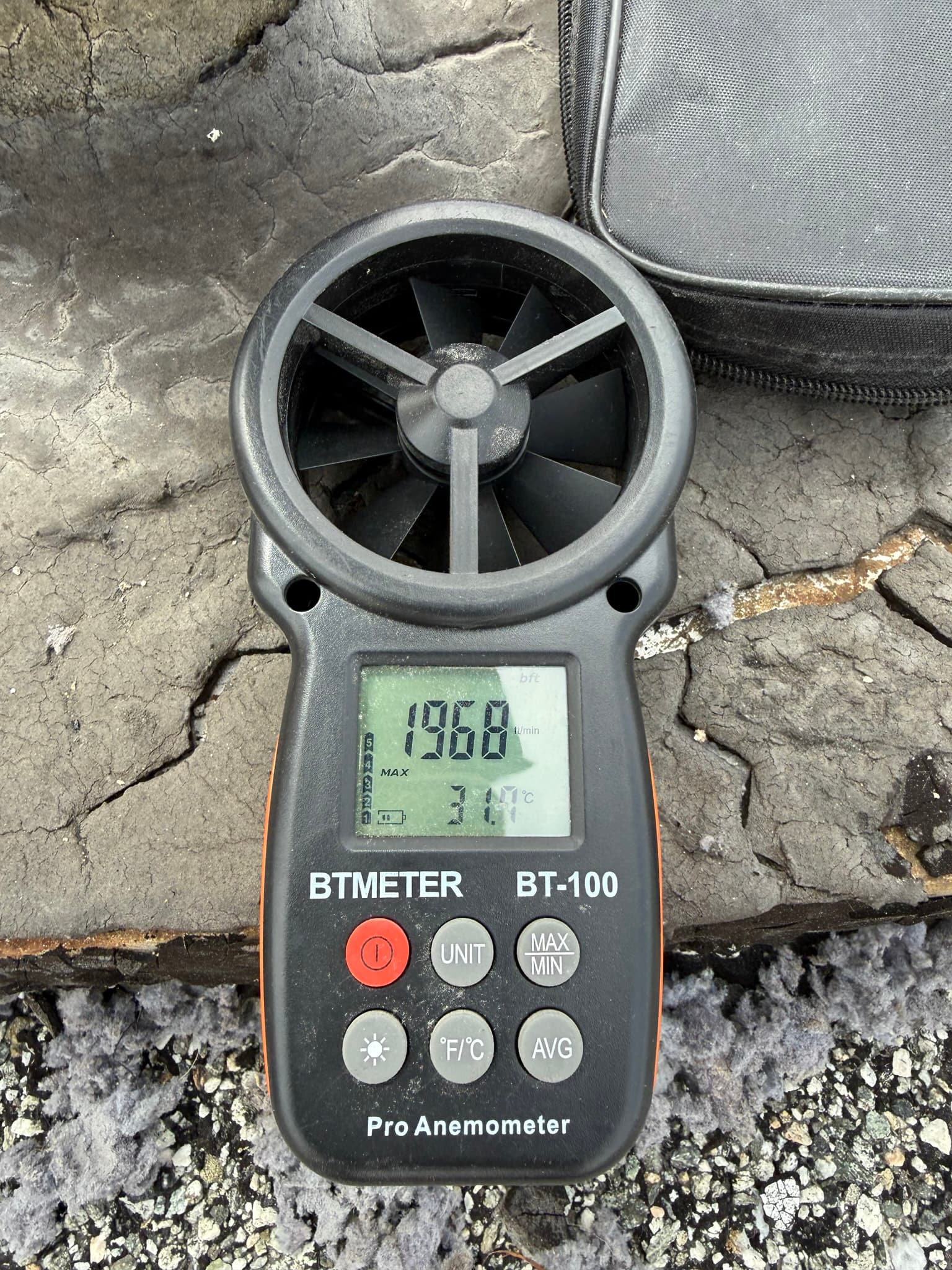 Hand-held BTMETER BT-100 Pro anemometer displaying an airflow reading of 1.96 meters per second used to measure exhaust velocity at the dryer vent outlet after service