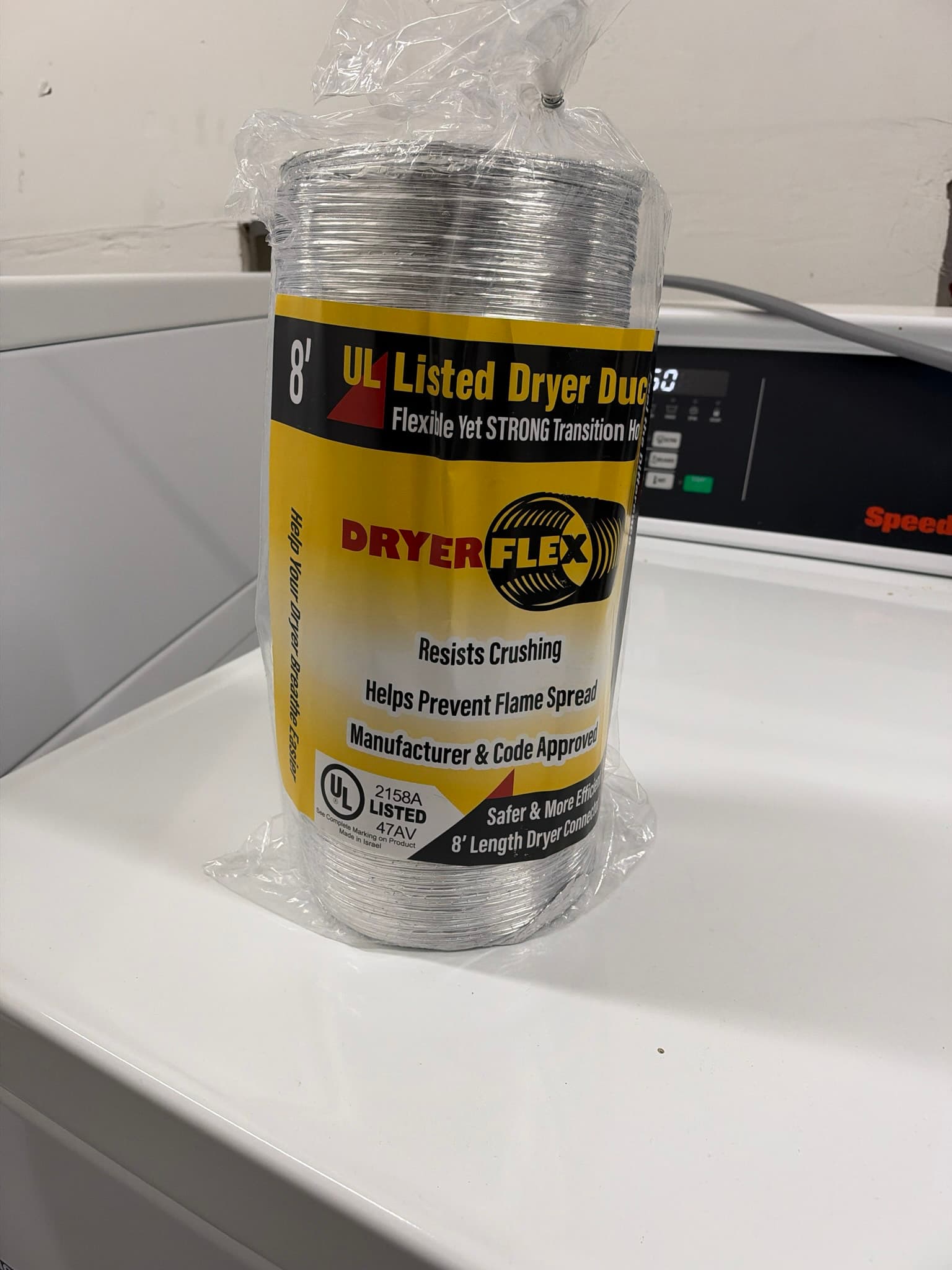 Unopened 8 foot package of UL 2158A listed DryerFlex transition duct staged on top of the dryer before installation