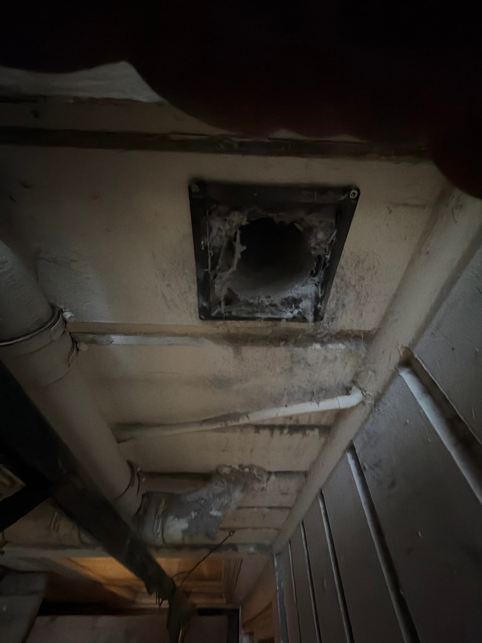 Technician working on the dryer exhaust connection point inside the laundry alcove