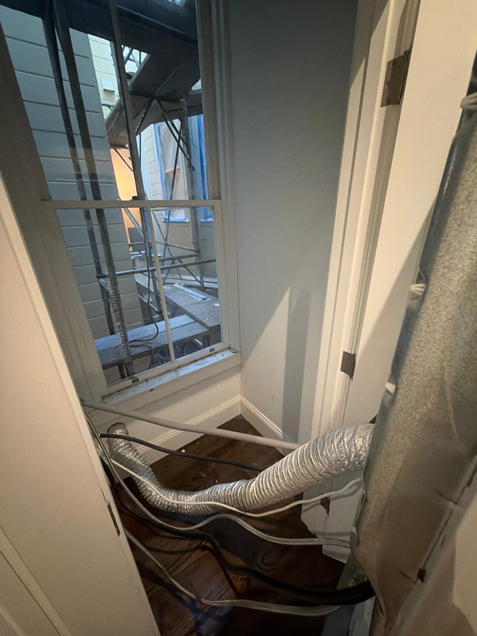 Close-up view of the laundry area during preparation for the new dryer wall vent and washer supply line installation