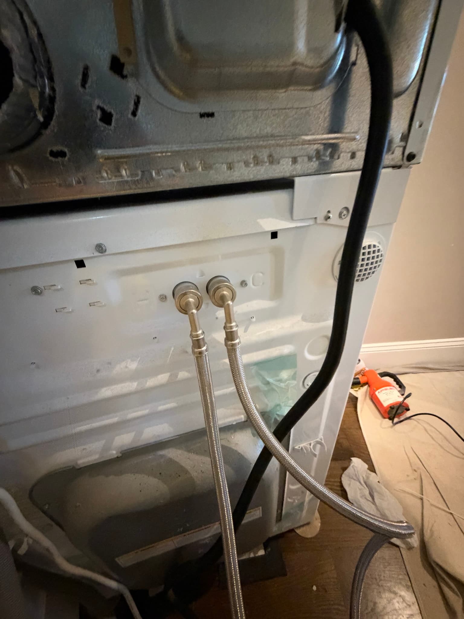 Stainless steel braided washing machine supply line being connected at the laundry hookup